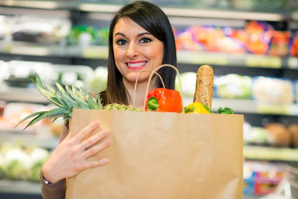 Woman holding bag full of vegetables