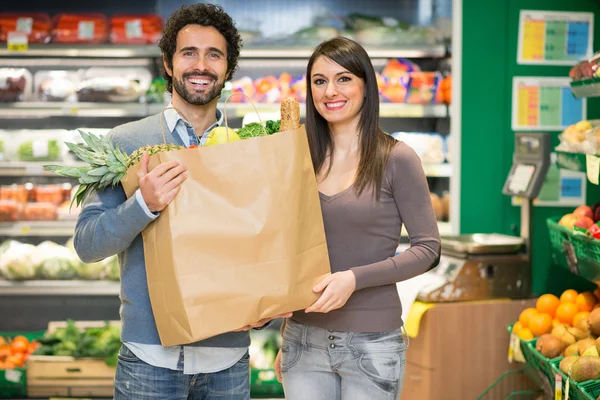 Couple holding a bag at the supermarket