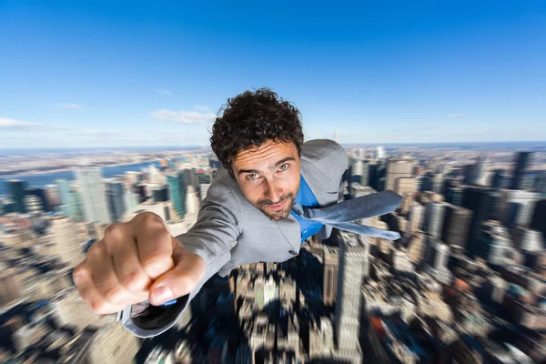 Businessman superhero flying over city
