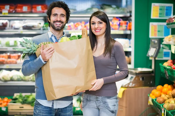 Couple holding bag at supermarket