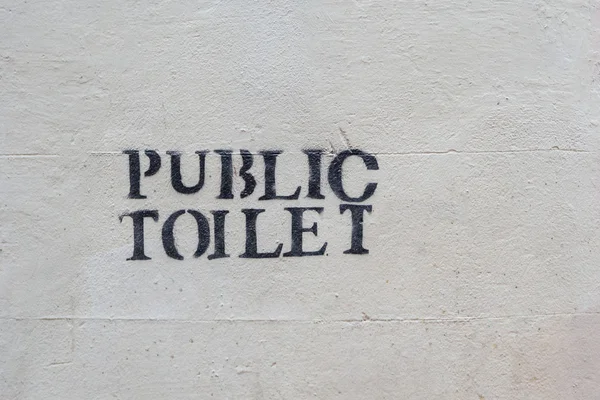 Public toilet stencil print on a wall as a label