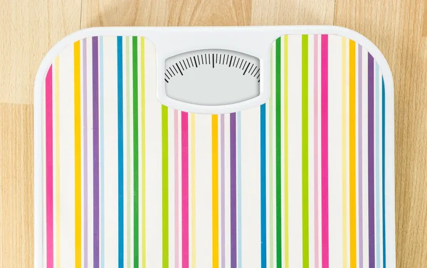 Bathroom scale with clean dial with lines no numbers on wooden floor