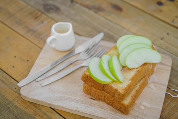 Apple with bread served on wood plate