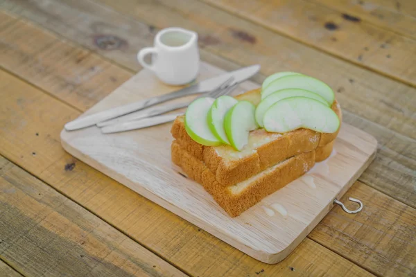 Apple with bread served on wood plate