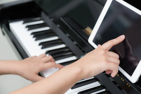 Woman hand use tablet and  playing piano music