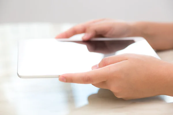 Woman hand touch white tablet with blank empty screen