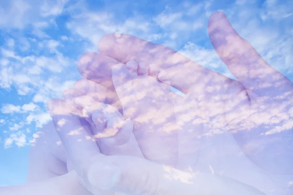 Sweet baby feet in double exposure with blue sky background