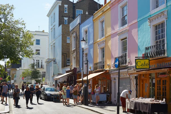 Portobello road with colorful houses and people in London