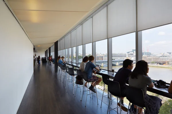 Tate Modern Art Gallery cafe interior with people and city view, London