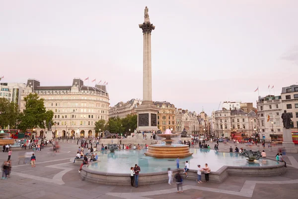 Trafalgar square with people and tourists at dusk in London