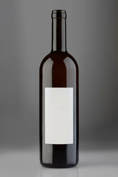 Opened red wine bottle with blank label on gray background