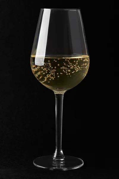 White sparkling wine glass on black background