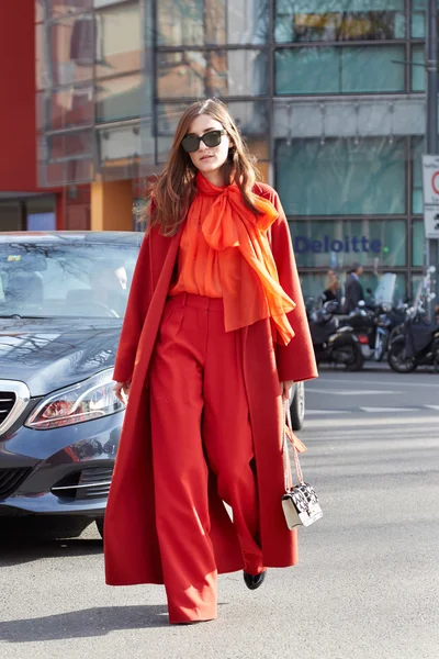 Eleonora Carisi poses for photographers with orange coat and trousers before Emporio Armani fashion show
