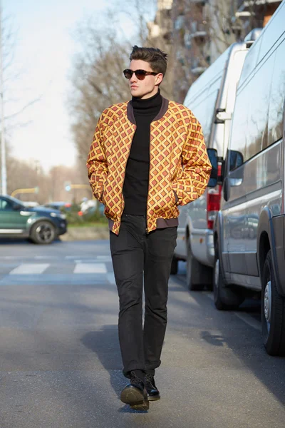 Man with yellow bomber jacket poses for photographers before Giorgio Armani show