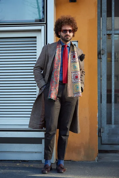 Elegant man poses for photographers before Giorgio Armani fashion show, street style