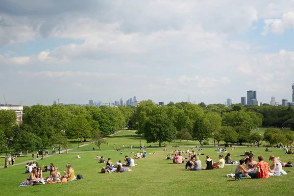 Primrose hill top with London city view and people in the park