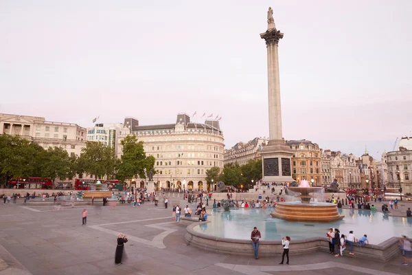 Trafalgar square with people and tourists in the evening, London