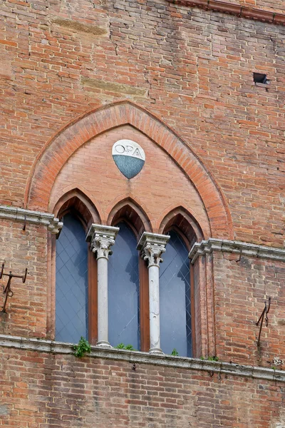 The typical three-part Sienese gothic windows of San Giovanni Square