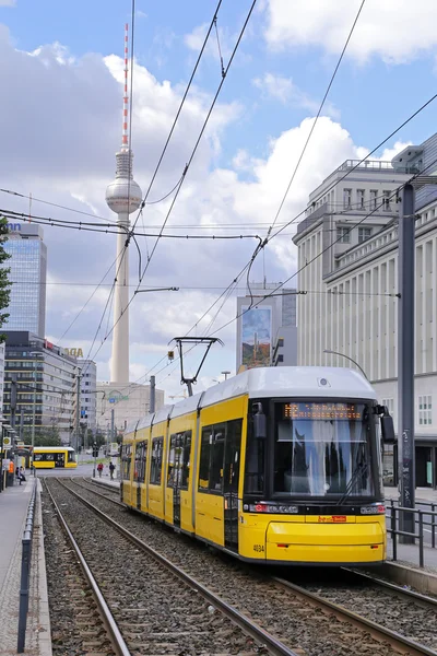 BERLIN, GERMANY - JULY 26: Yellow tram at Berlin Alexanderplatz. In the background you can see the TV tower and the station