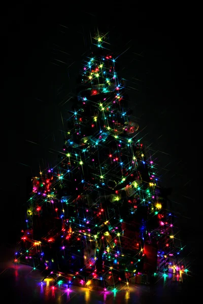 Decorated Christmas tree lit up with colorful lights at night