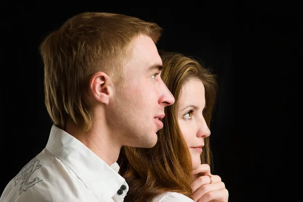 Young couple on black background.