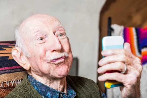 Older man taking silly face selfie