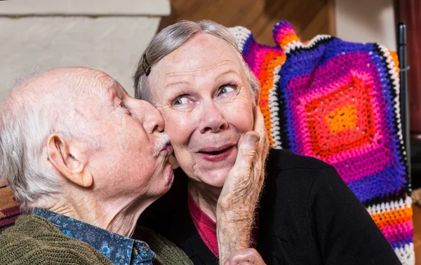 Elderly gentleman kissing woman