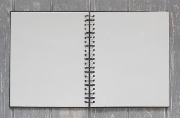 Note book on grey wooden desk.