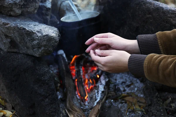 Woman warming hands near fire