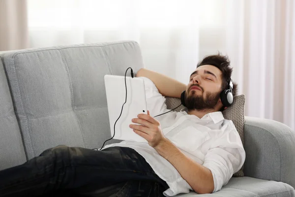 Young man listens music with headphones