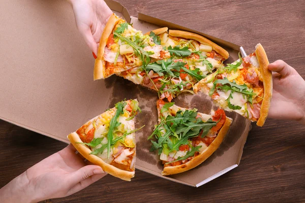 People hands with sliced pizza o