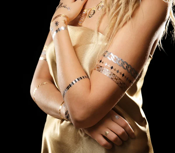 Young blonde girl with golden tattoo