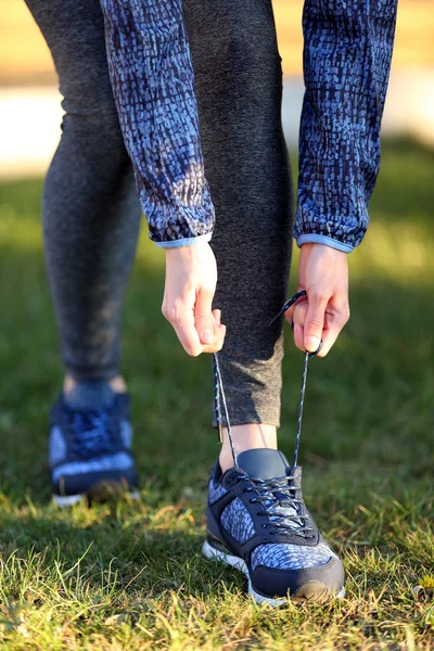 Woman in sportswear tying shoelaces