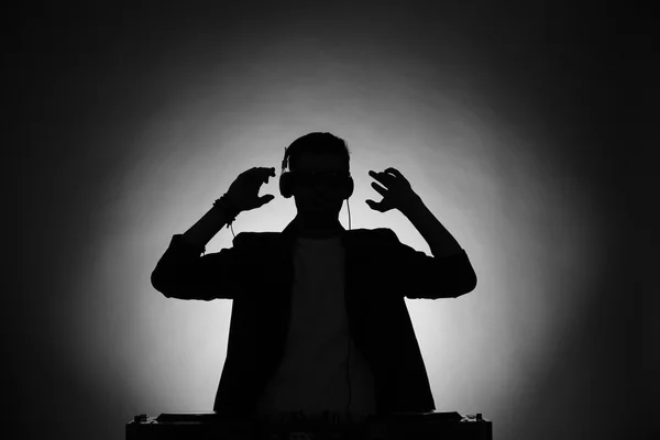 DJ playing music at mixer in dark