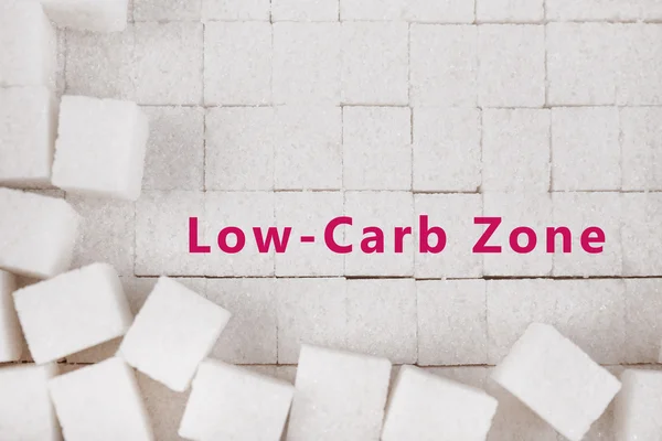 White refined sugar background and text Low-Carb Zone on it