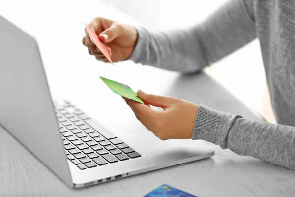 E-commerce concept. Woman with credit card and laptop, close up