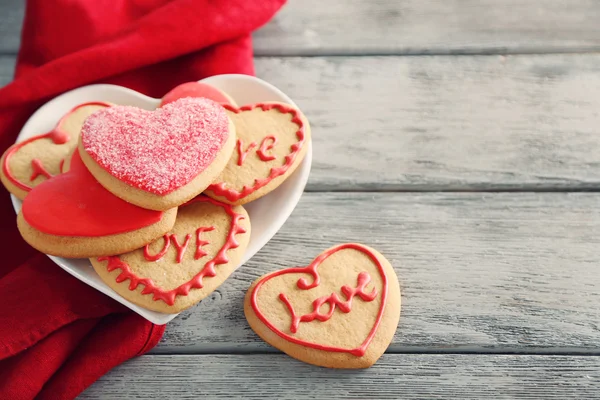 Assortment of love cookies with red cloth on grey wooden table background
