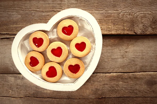 Assortment of love cookies in box on wooden background, closeup