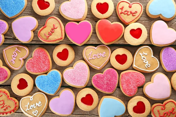 Assortment of love cookies on wooden background, closeup