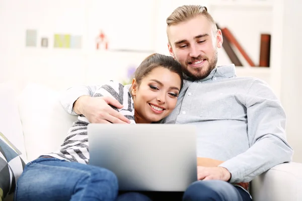 Happy couple and working on a laptop