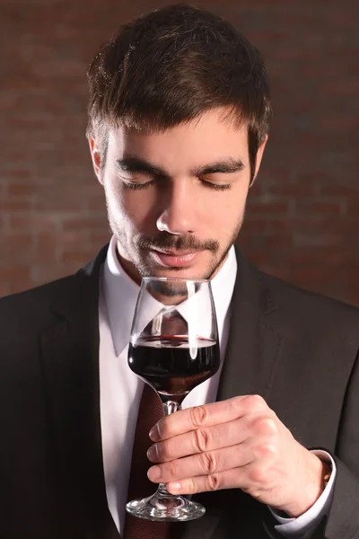 Man sniffing red wine in glass