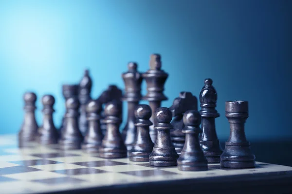 Chess pieces and game board on light green background