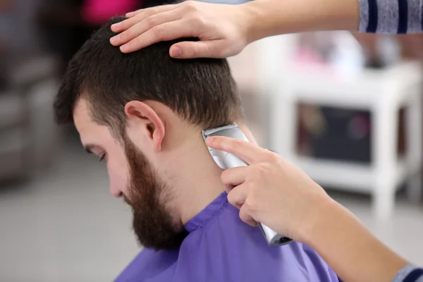 Hairdresser cutting hair with hair clipper