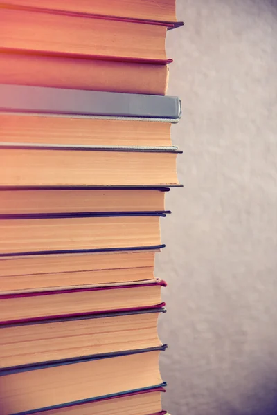 Stack of books on light wall background