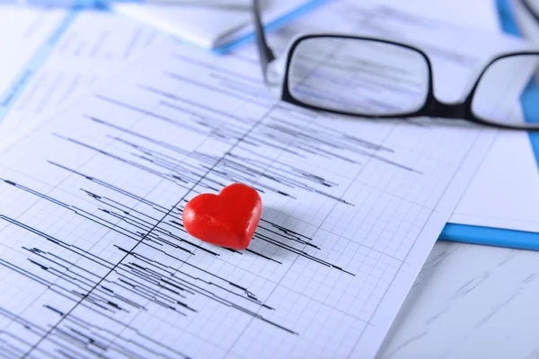 Cardiogram chart with glasses and small red heart