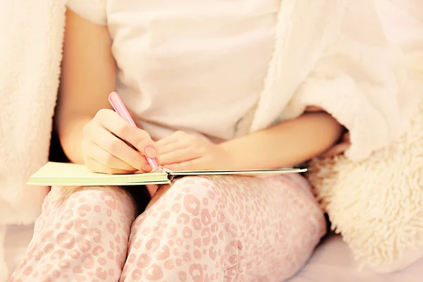 Woman in pajamas writing diary