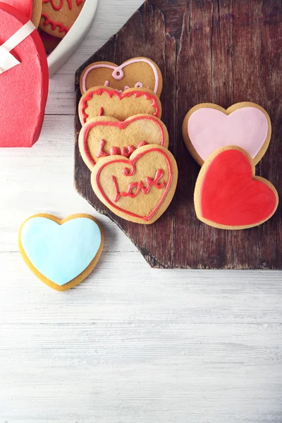 Valentine heart cookies with present box on wooden table, top view