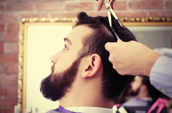 Hairdresser making stylish man haircut