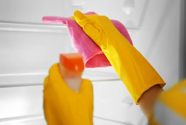 Hands in gloves washing refrigerator