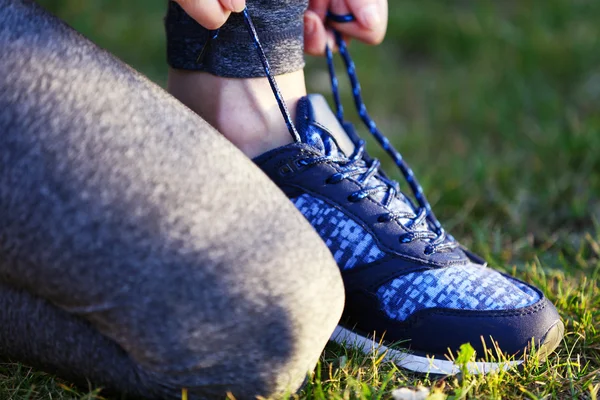 Woman in sportswear tying shoelaces